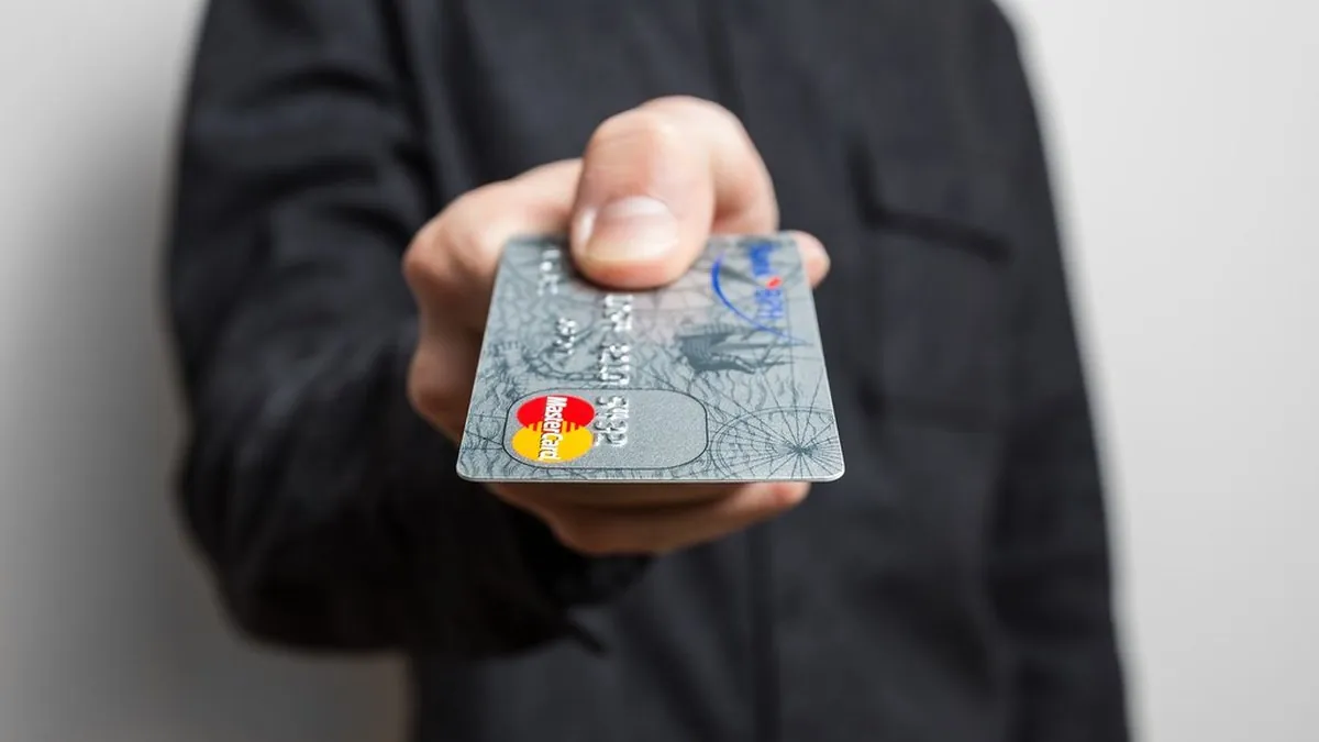 Mano che tiene una carta di pagamento